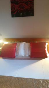 Earlston布鲁姆菲尔德住宿加早餐旅馆的一张带两个红色和白色枕头的床