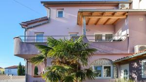 梅杜林梅杜林公寓的一座粉红色的建筑,前面有一棵棕榈树