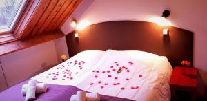 霍勒姆Hotel Dolores Ameland的卧室在床上装饰着红色玫瑰