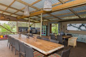 赫卢赫卢韦Zululand Lodge的一间带木桌和椅子的用餐室