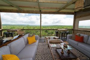 赫卢赫卢韦Zululand Lodge的客厅配有沙发和甲板上的桌子