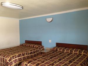 西尔马珍视旅馆的两张位于酒店客房的床,拥有蓝色的墙壁