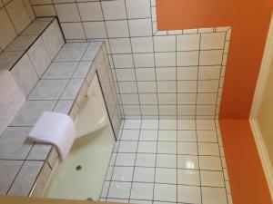 西尔马珍视旅馆的白色瓷砖浴室设有浴缸和卫生间。