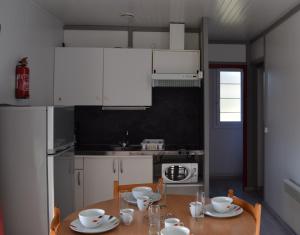 Boulogne-sur-GesseCamping - Village Vacances du Lac的厨房配有木桌和白色橱柜。