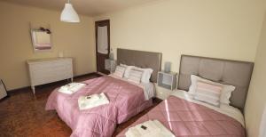 PerafitaCasarão Paraíso的配有粉红色床单的客房内的两张床