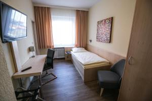 希尔德斯海姆伯格梅特卡佩旅馆的一间医院间,配有一张床、一张桌子和一把椅子