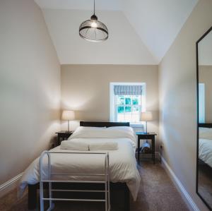 圣安德鲁斯Orchard Cottage的一间卧室设有一张大床和一个窗户。