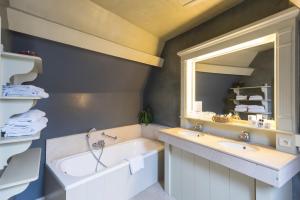 布鲁日Hotel Ter Brughe by CW Hotel Collection的带浴缸、水槽和镜子的浴室