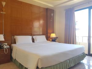 皮皮岛Phi Phi Hotel的卧室配有一张白色大床和木墙