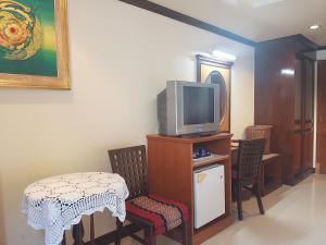 皮皮岛Phi Phi Hotel的客厅配有电视和桌椅