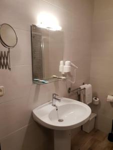 曼萨纳雷斯英雄传奇酒店的白色的浴室设有水槽和镜子