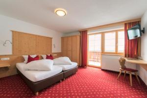 圣安东阿尔贝格巴切霍夫酒店的酒店客房设有两张床和电视。