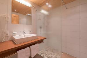 圣安东阿尔贝格巴切霍夫酒店的白色的浴室设有水槽和淋浴。