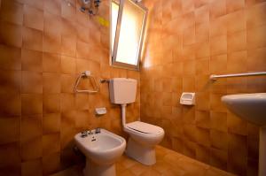 比比翁Appartamenti Calypso的一间带卫生间、水槽和镜子的浴室