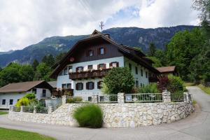 圣斯蒂凡安德Gästehaus im Wiesengrund的一座白色的大房子,前面有石墙