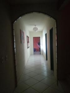 马约尔兰迪亚Casa Majorlandia的走廊通往带白色墙壁和瓷砖地板的客房