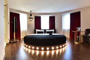 里斯本Maxime Hotel Lisbon的一间卧室配有一张大床,周围灯火环绕