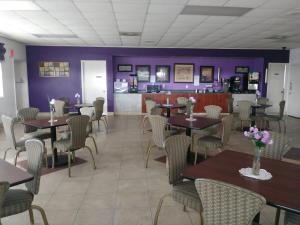 圣安东尼奥Knights Inn San Antonio near Frost Bank Center的一间设有桌椅和紫色墙壁的用餐室