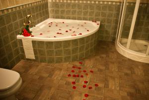 波索阿尔孔Casas Rurales Cazorla-Alcón的地板上的浴室设有红色玫瑰浴缸。