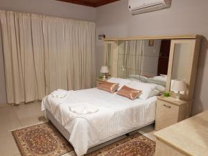 OshakatiRY Courtyard的卧室配有一张白色的床和大镜子