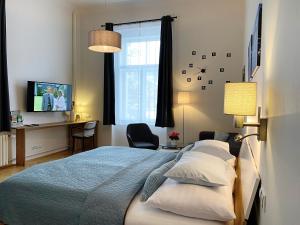 玛丽亚温泉Marienbad Apartment的一间卧室配有一张床、一张书桌和一台电视