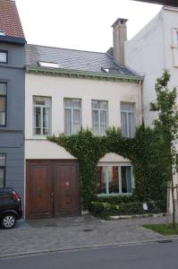 奥斯坦德Apt in center of Ostende 20min from Bruges的白色的房子,设有棕色的木制车库