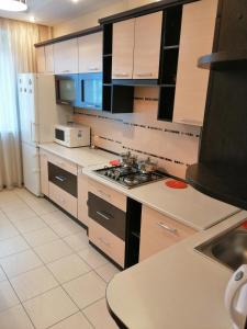 罗夫诺Big Apartment in Rivne center的厨房配有白色橱柜和炉灶烤箱。