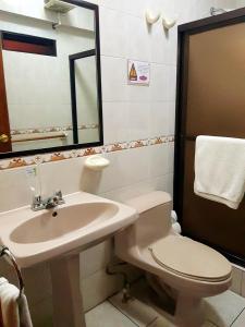 克萨尔特南戈Hotel Las Americas的一间带水槽、卫生间和镜子的浴室