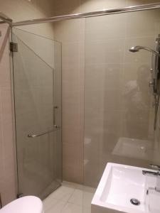 关丹V酒店 的一间带玻璃淋浴和水槽的浴室