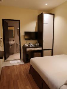 关丹V酒店 的酒店客房设有一张床、一张书桌和一间浴室。