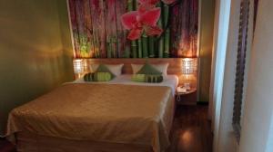 科特布斯Ahorn Hotel的卧室配有一张挂有花卉画的床铺。