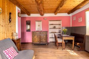 坎诺比奥阿蒂利奥乡村酒店的客厅配有桌子和粉红色的墙壁