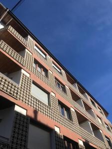 普奇塞达Apartamento Turístico Puigcerdá Correos的一座高大的砖砌建筑,设有白色的窗户