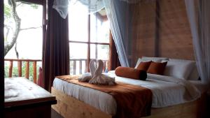 埃拉Saffron Eco Cottage的一间卧室设有一张大床和大窗户
