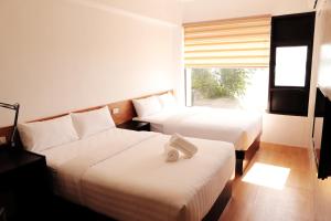 塔比拉兰Travelbee Seaside Inn的酒店客房设有两张床和窗户。