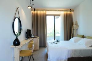 斯卡拉拉乔伊Filippos Hotel的一间卧室配有一张床、一张书桌和一面镜子