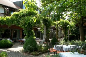 韦因斯贝格嘎斯嘎斯塔拉彭霍夫酒店的花园内带桌子和遮阳伞的庭院