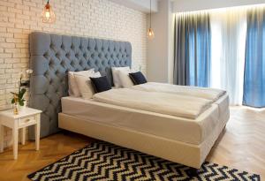 布加勒斯特Venis Boutique Hotel的一间卧室配有一张大床和蓝色床头板