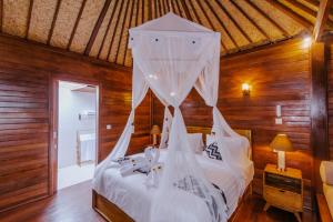 蓝梦岛Lembongan Small Heaven Bungalow的卧室配有带白色蚊帐的床