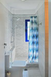卡尔利拉基Villa Chrysi的浴室配有蓝色的浴帘和卫生间