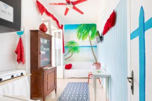 维拉诺瓦Casa Corallo的客厅的墙上挂着棕榈树画