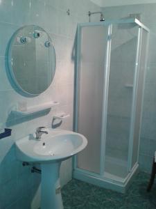 洛克里努拉蒙马酒店的浴室配有盥洗盆和带镜子的淋浴