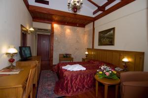 韦里亚艾吉斯梅拉松酒店的一间卧室配有一张床和一张鲜花桌子