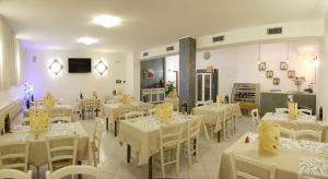 特雷维索ALA Hotel的用餐室配有白色的桌子和白色的椅子