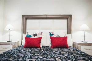 马拉加Apartamento Aurora的一间卧室配有一张带红色枕头的大床