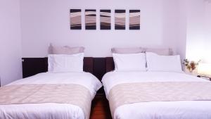 京都COCORO HOTEL的两张睡床彼此相邻,位于一个房间里