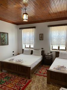 培拉特Guest House Iljesa的配有2张床的白色墙壁和窗户客房
