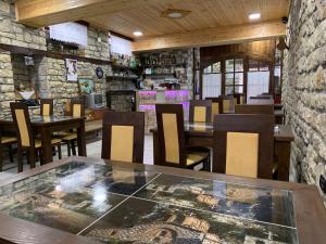 培拉特Guest House Iljesa的一间带桌椅和石墙的餐厅
