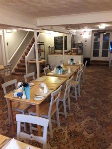 赖德怀特岛多西特住宿加早餐旅馆的用餐室配有木桌和白色椅子