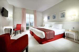 大桑卢卡尔桑卢卡尔大酒店的配有一张床和一把椅子的酒店客房
